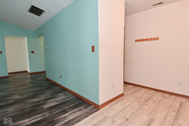 1411 Mimosa Ct, Greenfield, IN 46140 - empty room with wood finished floors, a textured ceiling, and lofted ceiling