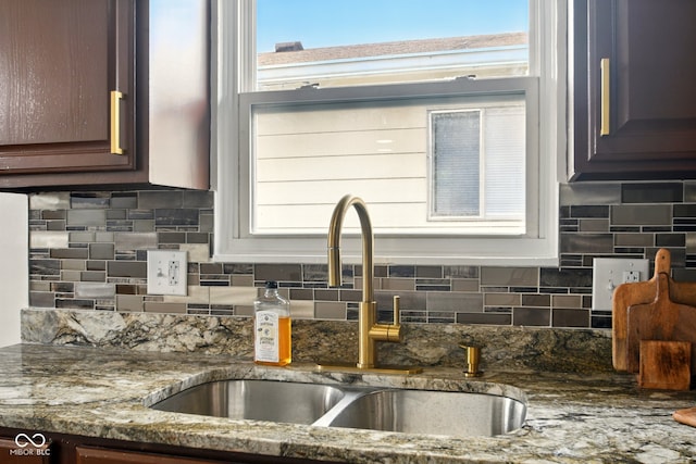 1513 S Rural St, Indianapolis, IN 46203 - kitchen featuring a sink, tasteful backsplash, stone counters, and dark brown cabinetry