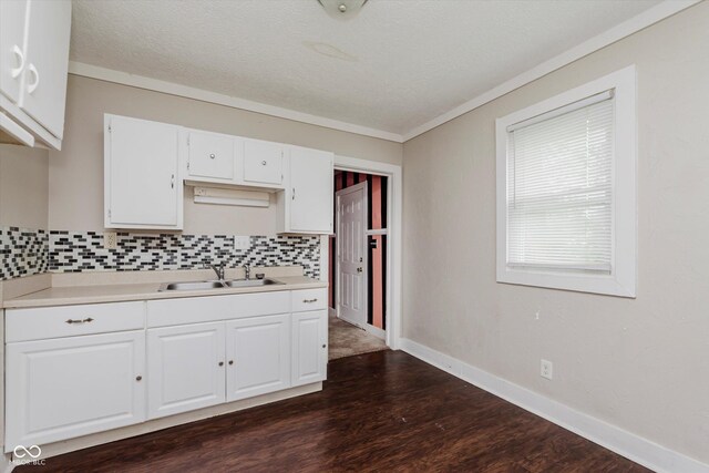 1938 N Dearborn St, Indianapolis, IN 46218 - kitchen with light countertops, backsplash, white cabinetry, dark wood-style flooring, and a textured ceiling