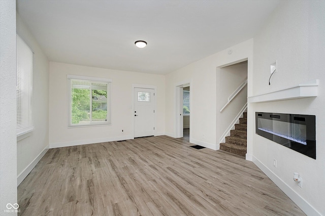 1038 W 33rd St, Indianapolis, IN 46208 - foyer entrance with light wood-style flooring, a glass covered fireplace, and stairway