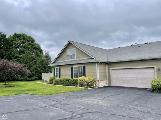 125 Bridgemor Ln, Mooresville, IN 46158 - view of front of house with asphalt driveway, an attached garage, a front lawn, a shingled roof, and stone siding