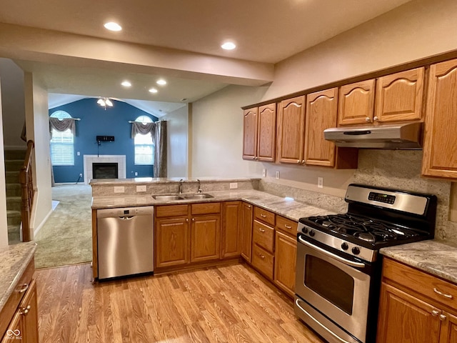 125 Bridgemor Ln, Mooresville, IN 46158 - kitchen featuring stainless steel appliances, under cabinet range hood, a sink, a peninsula, and a tiled fireplace