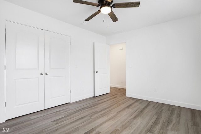 1612 Paula Dr, Columbus, IN 47201 - unfurnished bedroom with wood finished floors, baseboards, a closet, and ceiling fan