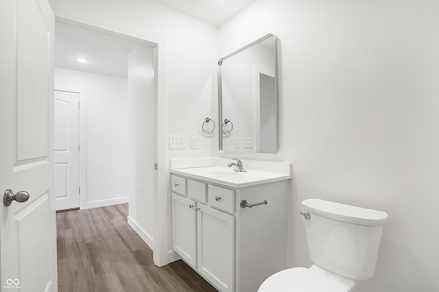 1612 Paula Dr, Columbus, IN 47201 - half bath with vanity, wood finished floors, toilet, and recessed lighting