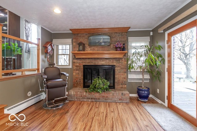 2457 N Centerline Rd, Franklin, IN 46131 - living area with baseboard heating, wood finished floors, a fireplace, baseboards, and a textured ceiling