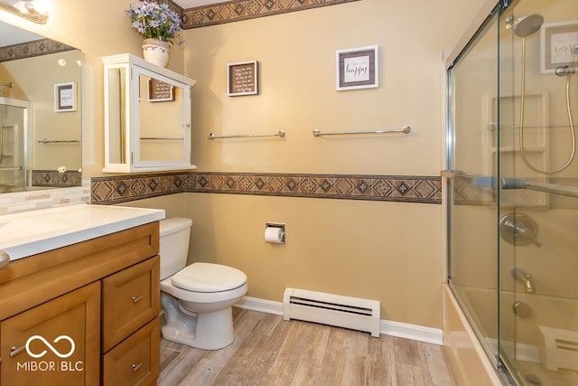 2457 N Centerline Rd, Franklin, IN 46131 - bathroom featuring baseboard heating, vanity, toilet, enclosed tub / shower combo, and wood finished floors