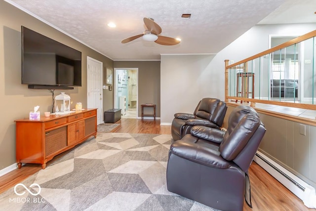 2457 N Centerline Rd, Franklin, IN 46131 - living area featuring a baseboard radiator, a ceiling fan, light wood-type flooring, baseboards, and ornamental molding