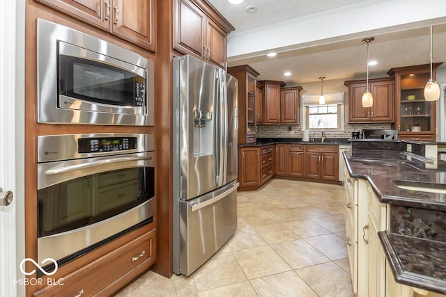 2457 N Centerline Rd, Franklin, IN 46131 - kitchen with appliances with stainless steel finishes, a sink, backsplash, pendant lighting, and brown cabinetry