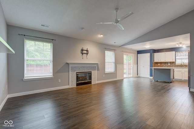 7918 Bitternut Dr, Indianapolis, IN 46236 - unfurnished living room featuring ceiling fan, a fireplace, a sink, vaulted ceiling, and dark wood-style floors