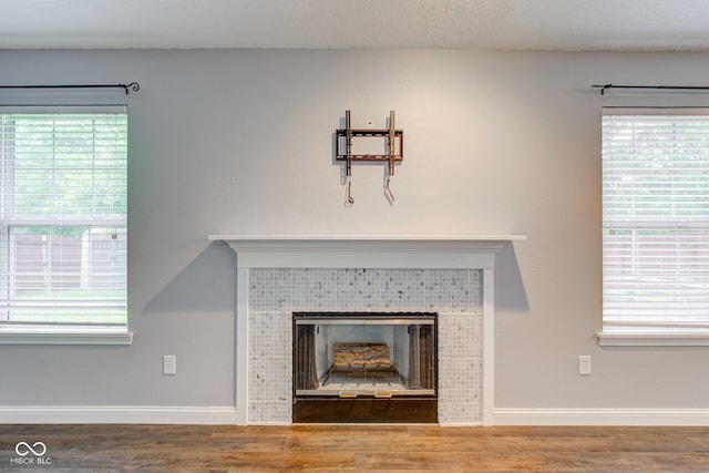 7918 Bitternut Dr, Indianapolis, IN 46236 - detailed view of a tiled fireplace, baseboards, and wood finished floors