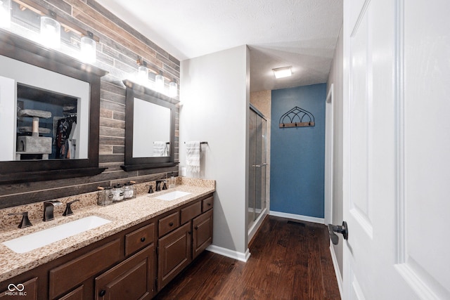 7686 Micawber Ct, Indianapolis, IN 46256 - bathroom featuring a shower stall, wood finished floors, double vanity, and a spacious closet