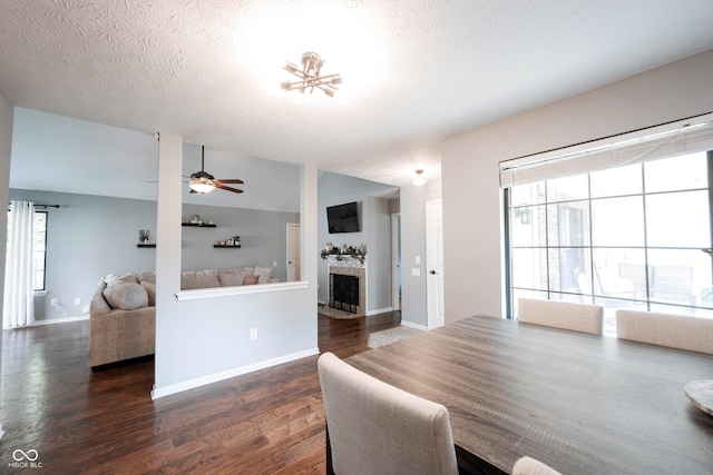 7686 Micawber Ct, Indianapolis, IN 46256 - dining space featuring wood finished floors, a fireplace, a textured ceiling, and ceiling fan