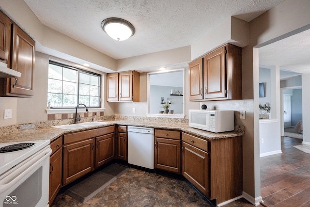 7686 Micawber Ct, Indianapolis, IN 46256 - kitchen featuring white appliances, light countertops, brown cabinetry, and a textured ceiling