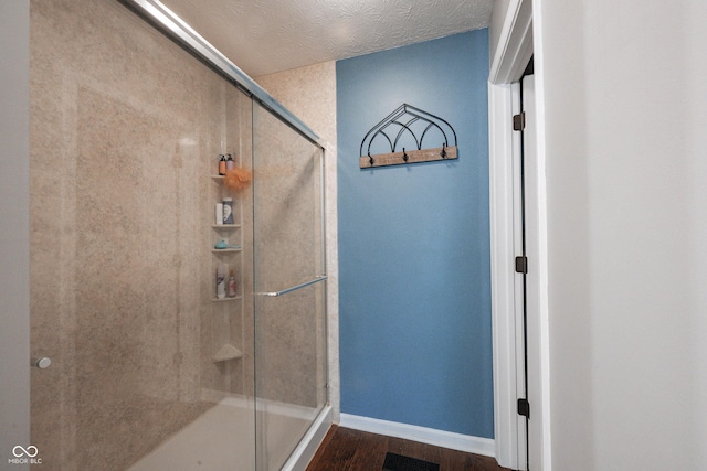 7686 Micawber Ct, Indianapolis, IN 46256 - bathroom with a stall shower, wood finished floors, and a textured ceiling