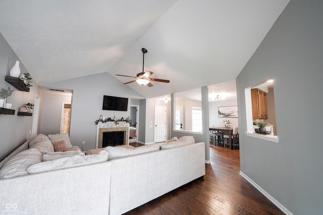 7686 Micawber Ct, Indianapolis, IN 46256 - living room featuring ceiling fan, dark wood-style flooring, a fireplace, and vaulted ceiling