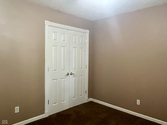 108 Meadowview Dr, Mooresville, IN 46158 - unfurnished bedroom with baseboards, a closet, and dark colored carpet