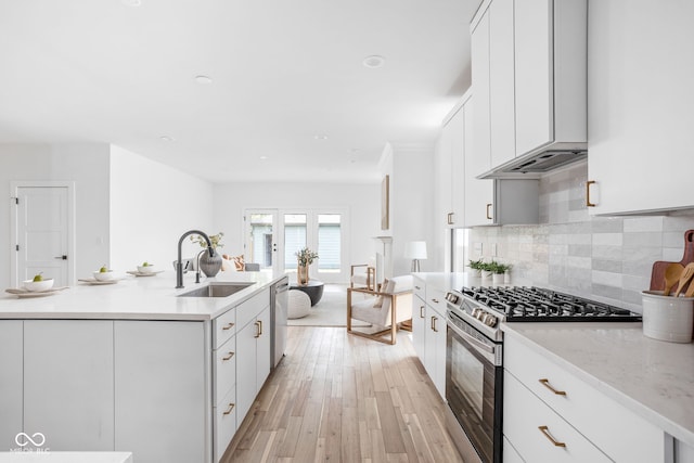 1717 Carrollton Ave, Indianapolis, IN 46202 - kitchen featuring appliances with stainless steel finishes, backsplash, light wood-style floors, white cabinetry, and light stone countertops