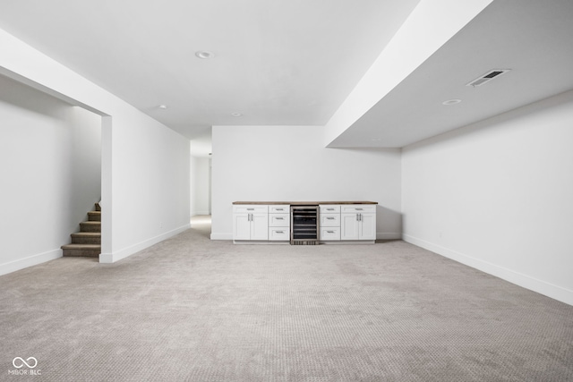 1717 Carrollton Ave, Indianapolis, IN 46202 - basement featuring beverage cooler, a dry bar, light carpet, and stairway