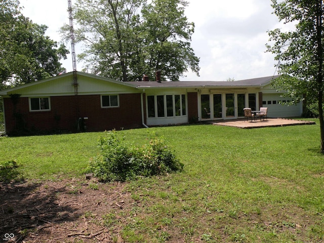 1796 N 400 W, Crawfordsville, IN 47933 - rear view of house with brick siding, an attached garage, a lawn, and a patio area