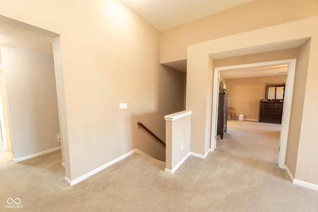 226 S Cave Creek Dr S, Bloomington, IN 47403 - hallway featuring an upstairs landing, light carpet, baseboards, and a textured ceiling