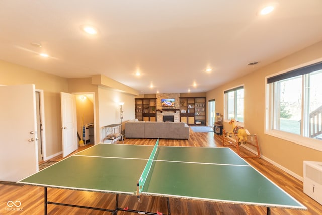 226 S Cave Creek Dr S, Bloomington, IN 47403 - playroom featuring a fireplace, wood finished floors, recessed lighting, baseboards, and radiator heating unit