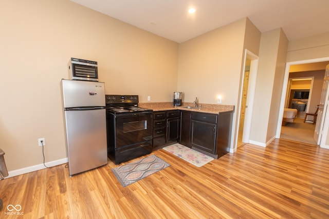 226 S Cave Creek Dr S, Bloomington, IN 47403 - kitchen with freestanding refrigerator, black electric range oven, light wood-style floors, a sink, and baseboards