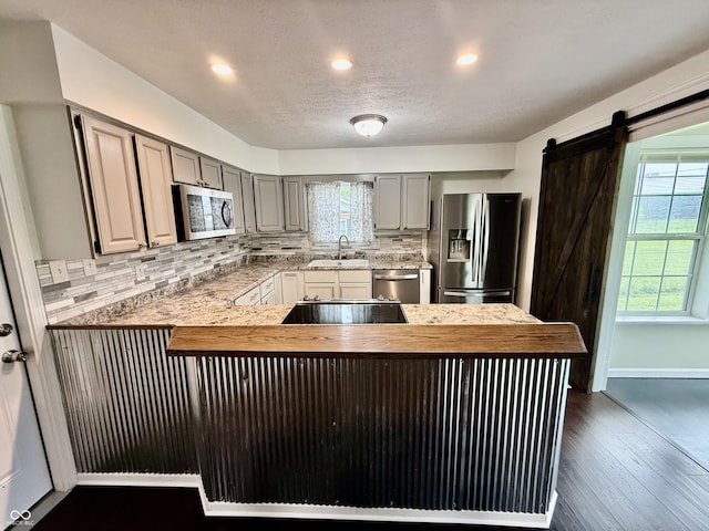 1002 Meadow Ln, Greencastle, IN 46135 - kitchen featuring appliances with stainless steel finishes, healthy amount of natural light, a peninsula, tasteful backsplash, and recessed lighting