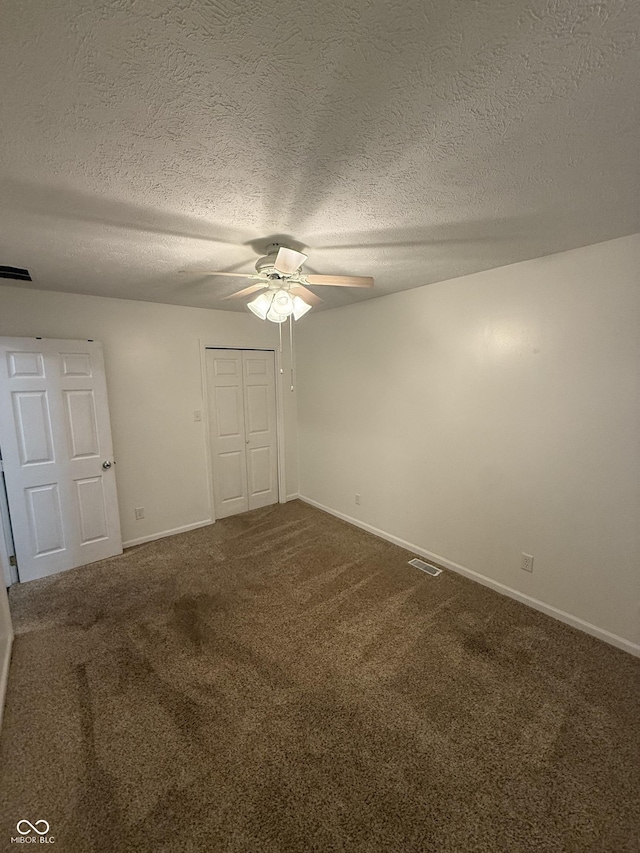 1002 Meadow Ln, Greencastle, IN 46135 - unfurnished bedroom featuring a closet, dark colored carpet, baseboards, and a textured ceiling