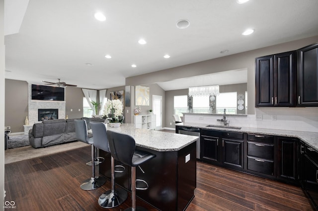 1143 Hampton Dr, Greenwood, IN 46143 - kitchen featuring a kitchen bar, dishwasher, light stone countertops, ceiling fan, and open floor plan