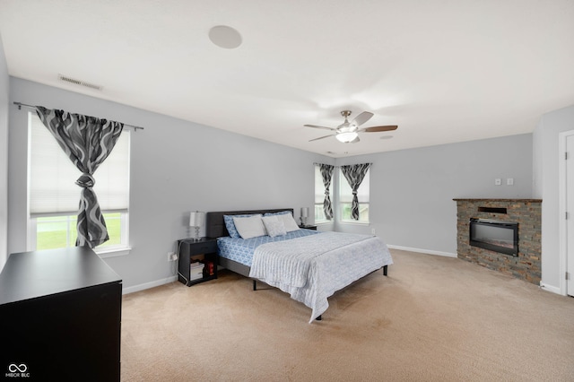 1143 Hampton Dr, Greenwood, IN 46143 - bedroom featuring multiple windows, light colored carpet, a stone fireplace, and ceiling fan