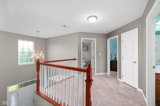 1143 Hampton Dr, Greenwood, IN 46143 - hallway featuring a chandelier, carpet, and an upstairs landing