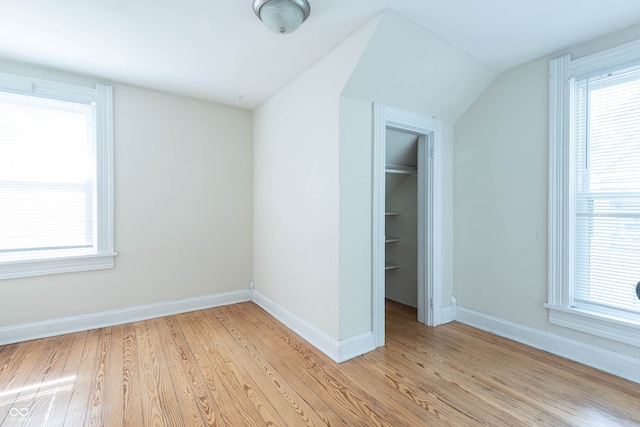 308 S Madison St, Bloomington, IN 47403 - unfurnished bedroom featuring light wood-style floors, baseboards, vaulted ceiling, and multiple windows