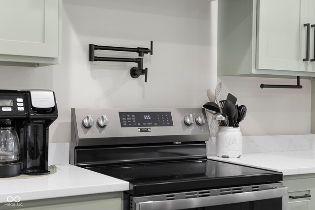 3365 Riverside Dr, Columbus, IN 47203 - kitchen view of stainless steel electric range oven, pot filler, and white cabinets