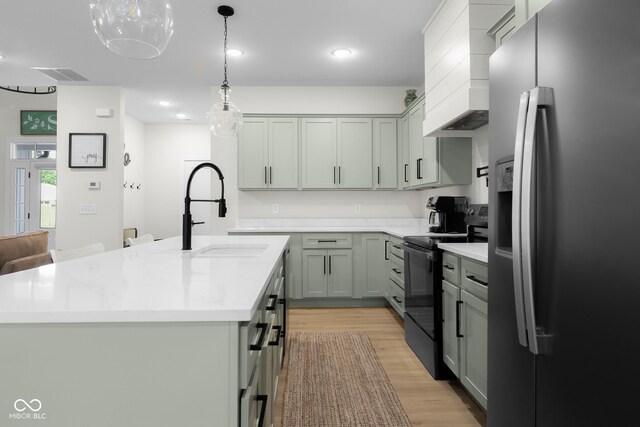 3365 Riverside Dr, Columbus, IN 47203 - kitchen with stainless steel fridge with ice dispenser, black electric range, a sink, light wood-style floors, and an island with sink