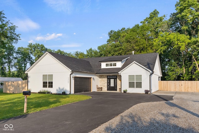 3365 Riverside Dr, Columbus, IN 47203 - view of front of home featuring an attached garage, driveway, stone siding, and roof with shingles