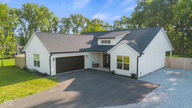 3365 Riverside Dr, Columbus, IN 47203 - modern farmhouse featuring driveway, a garage, roof with shingles, and stone siding