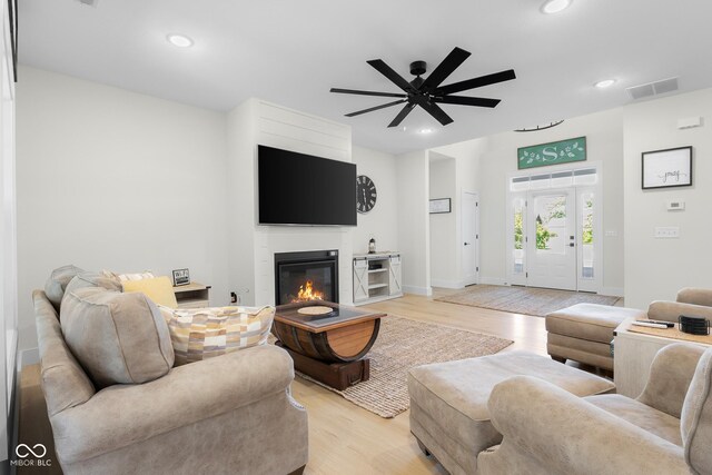 3365 Riverside Dr, Columbus, IN 47203 - living room featuring light wood-style floors, a ceiling fan, recessed lighting, a glass covered fireplace, and baseboards
