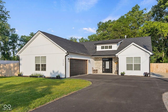 3365 Riverside Dr, Columbus, IN 47203 - view of front of house with a garage, driveway, stone siding, and roof with shingles