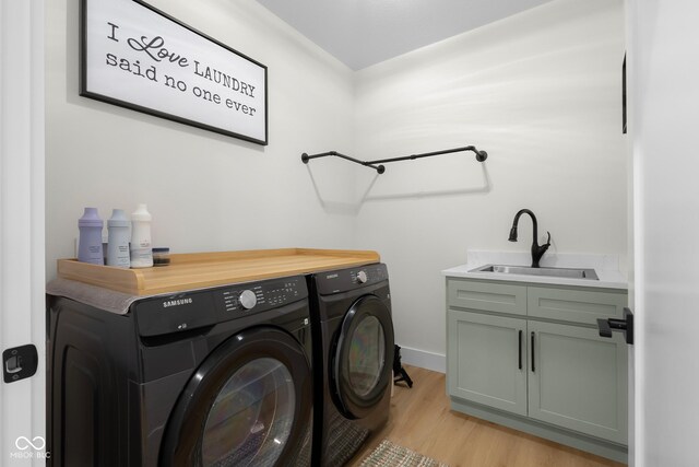 3365 Riverside Dr, Columbus, IN 47203 - laundry room featuring washer and dryer, cabinet space, light wood-type flooring, and baseboards