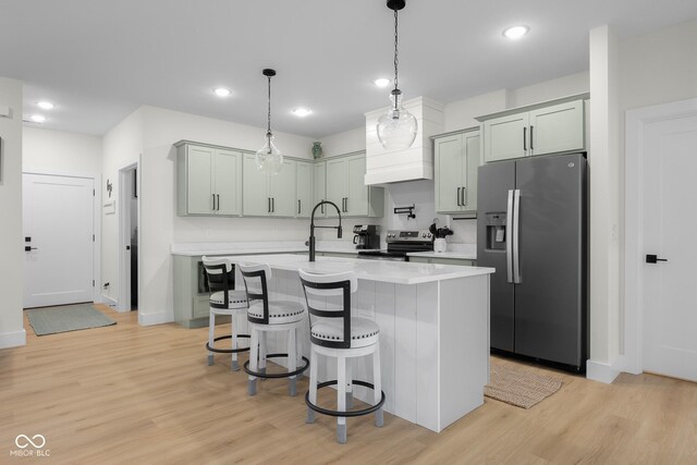 3365 Riverside Dr, Columbus, IN 47203 - kitchen featuring appliances with stainless steel finishes, light wood-type flooring, light countertops, a kitchen breakfast bar, and recessed lighting