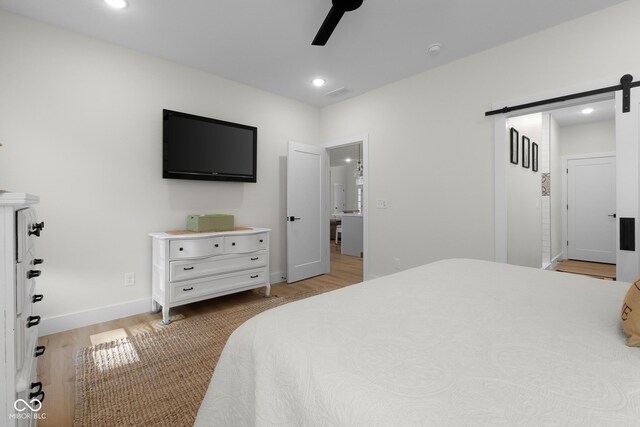 3365 Riverside Dr, Columbus, IN 47203 - bedroom featuring a barn door, light wood finished floors, recessed lighting, baseboards, and a ceiling fan