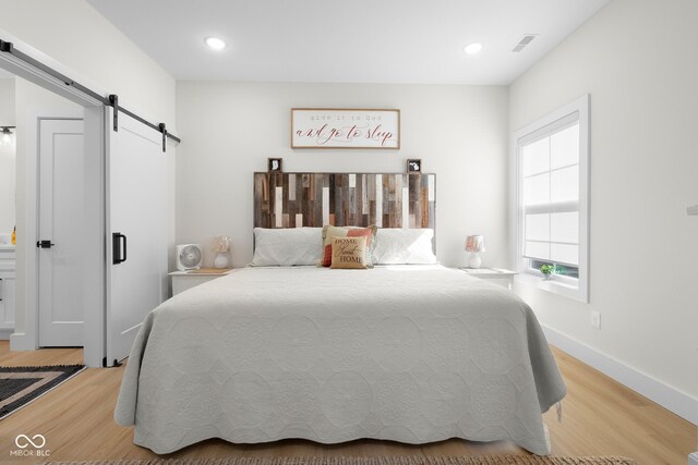3365 Riverside Dr, Columbus, IN 47203 - bedroom featuring a barn door, light wood finished floors, recessed lighting, and baseboards