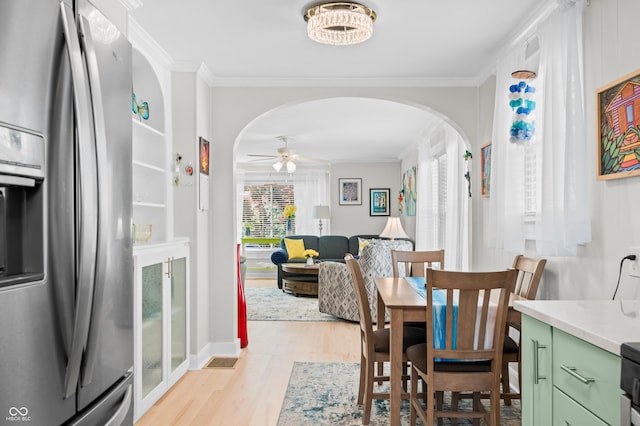 188 Maple Ln, Franklin, IN 46131 - dining room featuring arched walkways, light wood-type flooring, ornamental molding, and a ceiling fan