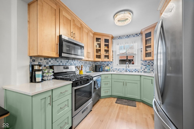 188 Maple Ln, Franklin, IN 46131 - kitchen with stainless steel appliances, green cabinets, light wood finished floors, and tasteful backsplash