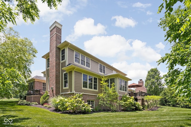4529 Panthera Leo Dr, Carmel, IN 46074 - rear view of property featuring a chimney, brick siding, and a lawn