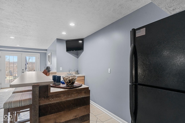 128 Walts Rd, Georgetown, IN 47122 - kitchen with freestanding refrigerator, light tile patterned floors, french doors, baseboards, and light countertops