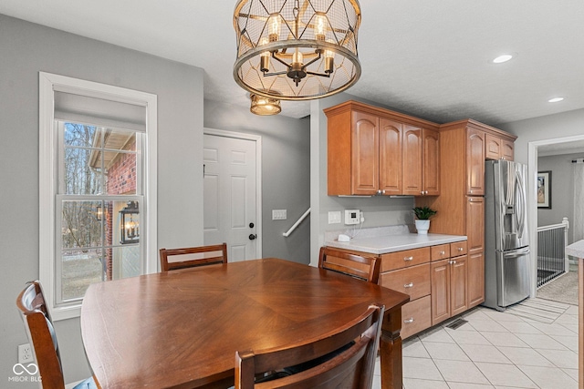 128 Walts Rd, Georgetown, IN 47122 - kitchen with stainless steel fridge with ice dispenser, light countertops, brown cabinetry, light tile patterned flooring, and recessed lighting