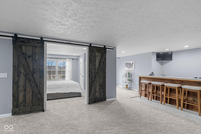 128 Walts Rd, Georgetown, IN 47122 - unfurnished room with a barn door, bar, carpet flooring, a textured ceiling, and baseboards