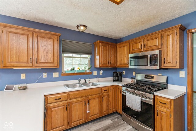 1159 Oak Leaf Rd, Franklin, IN 46131 - kitchen with appliances with stainless steel finishes, light countertops, light wood-style floors, and a textured ceiling