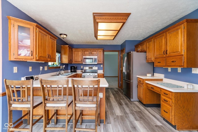 1159 Oak Leaf Rd, Franklin, IN 46131 - kitchen with appliances with stainless steel finishes, a peninsula, a textured ceiling, light countertops, and light wood-style floors